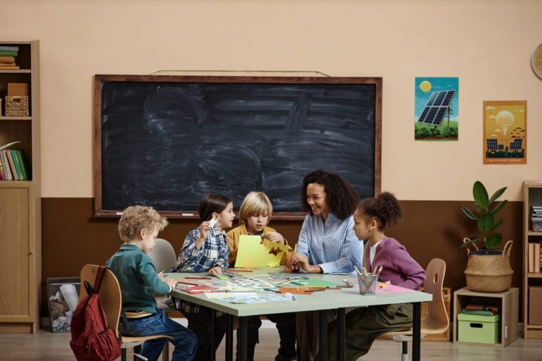 Group of children with teacher working on crafts in a classroom