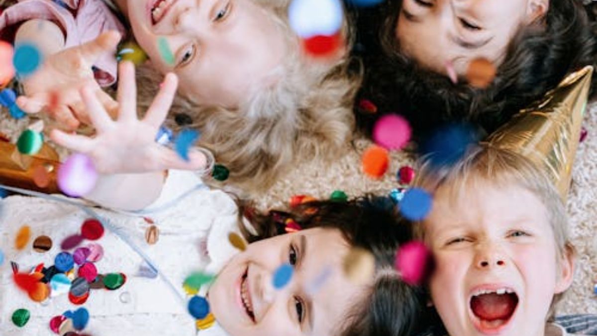 Children sitting in a circle, enjoying a therapy session, smiling as colorful confetti falls around them.