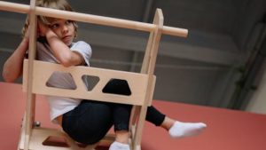 Young boy sitting calmly in a playroom at night and looking calm. 