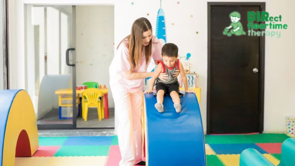 Play therapy NJ female therapist guiding a young boy on a slide in the playroom to encourage growth and confidence.
