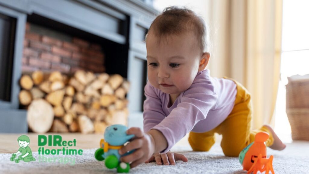 A 6-month-old crawls across a carpeted floor, exploring colorful plastic toys with eager curiosity.