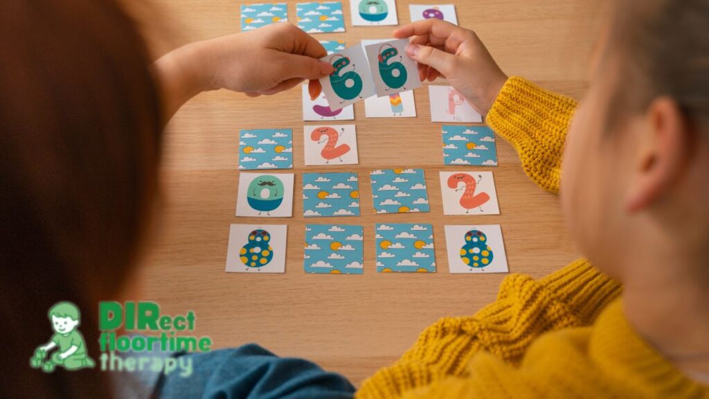 Two children with their backs to the camera work on a Math Bingo puzzle spread across a wooden table, illustrating brain games for kids.