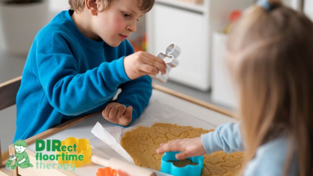 A boy and a girl play with sand together as they prepare materials for a sensory bin.