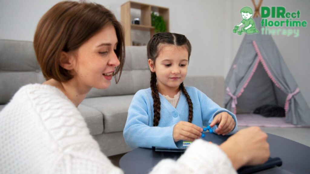 A therapist guides a young girl through a bead-making activity at a table in the living room.