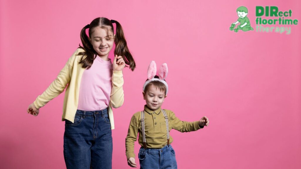A girl and a younger boy perform a dance movement together during a play activity.