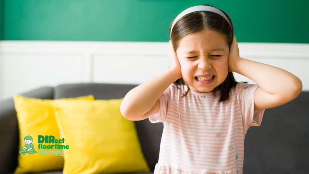 A child showing a child in genuine overwhelm with hands over ears: Meltdown or Tantrum