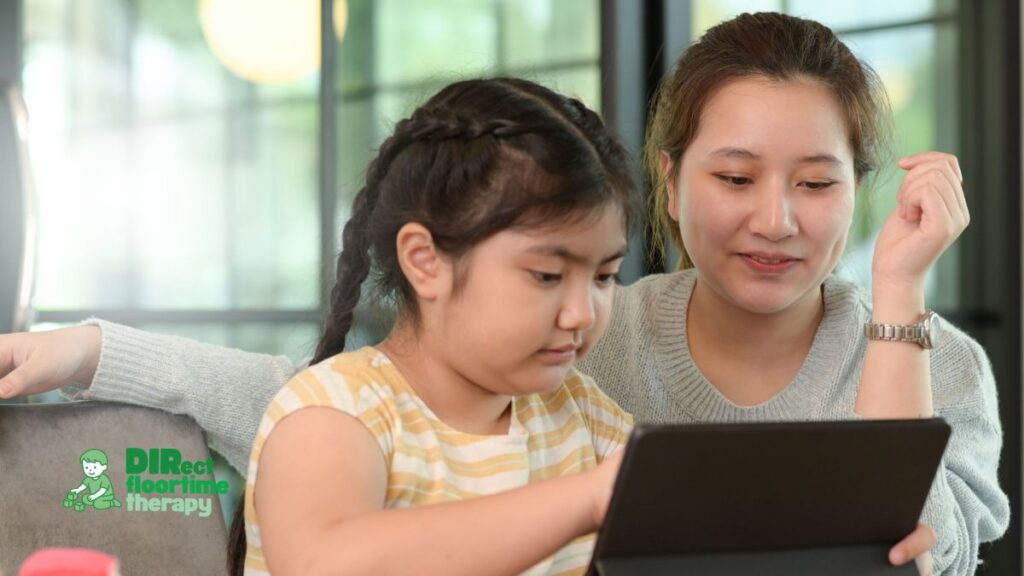 Child with autism using screen time constructively through an AAC app on a tablet while a DIR/Floortime therapist or NJ parent engages in interactive communication and helps set healthy screen time limits.