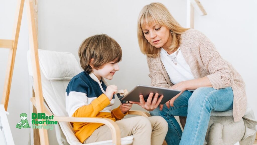 Screen Time and Autism: What the Research Actually Says and How DIR/Floortime Helps NJ Parents Set Limits Without Battles 1 Child with autism using screen time constructively through an AAC app on a tablet while a DIR/Floortime therapist or NJ parent engages in interactive communication and helps set healthy screen time limits.