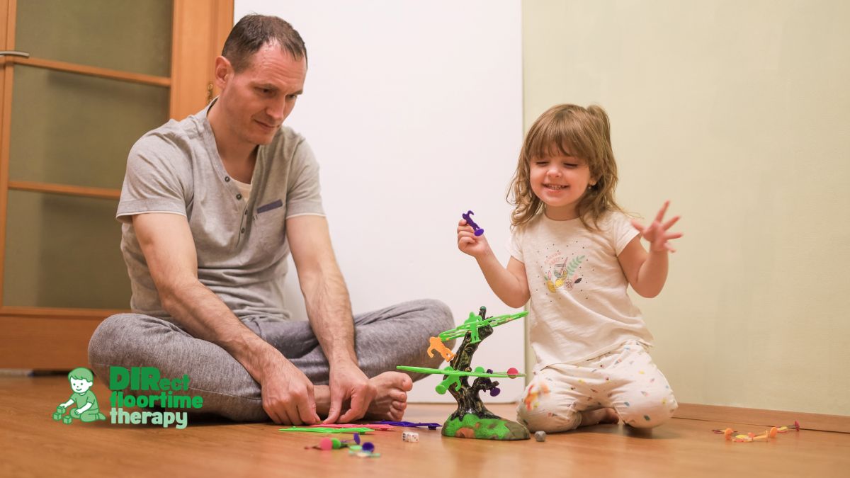 A parent and young child on the floor together, both looking at the same toy, the child beginning to vocalise or gesture toward it, capturing a joint attention moment : 'parent child floor joint attention toy vocalise autism language NJ'
